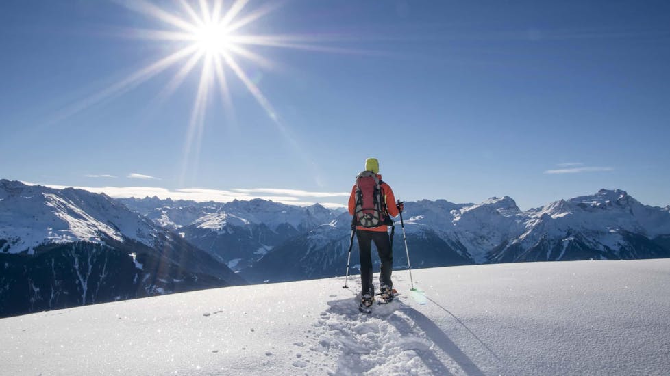 Eine Person blickt bei der Aktivität "Schneeschuhwanderung für alle Levels" mit dem Anbieter 1. Skischule Club Alpin Grän auf das umliegende Bergpanorama.