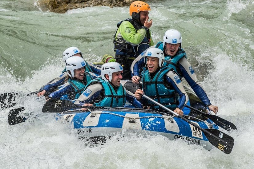 A group of friends has great fun rafting with UR Pirineos while they paddle through the wild rapids.
