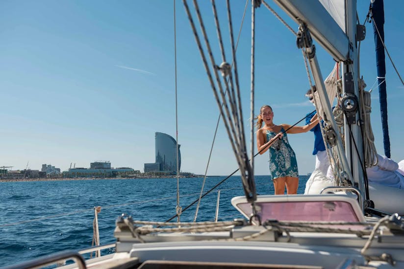 Una chica disfruta de un paseo en velero por el litoral de Barcelona con Vela Boat Trips.