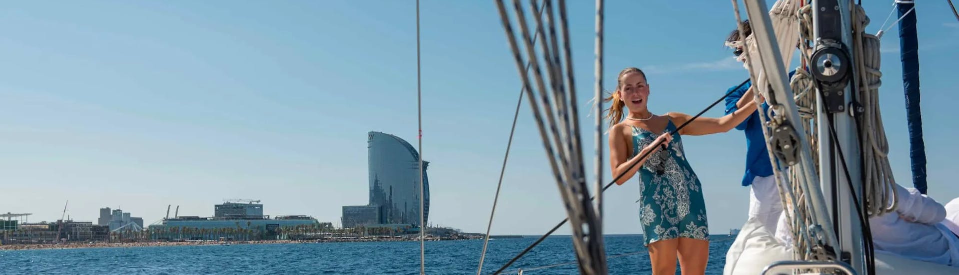 A girl enjoys a sailing boat trip along Barcelona's coastline with Vela Boat Trips. 