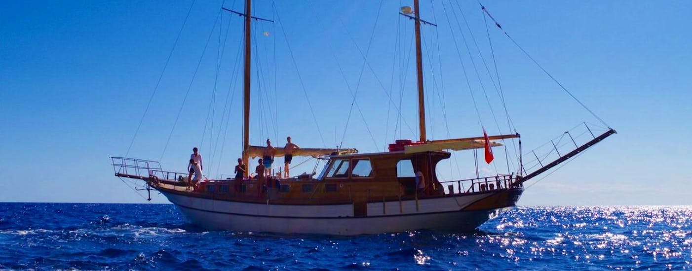 The elegant Veliero Kontes Gemma schooner in the open sea during a private trip along the Gulf of Orosei.