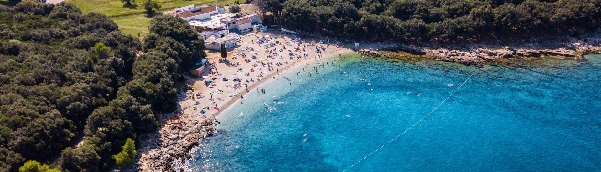 Mensen vermaken zich op het strand in Verudela in Kroatië.