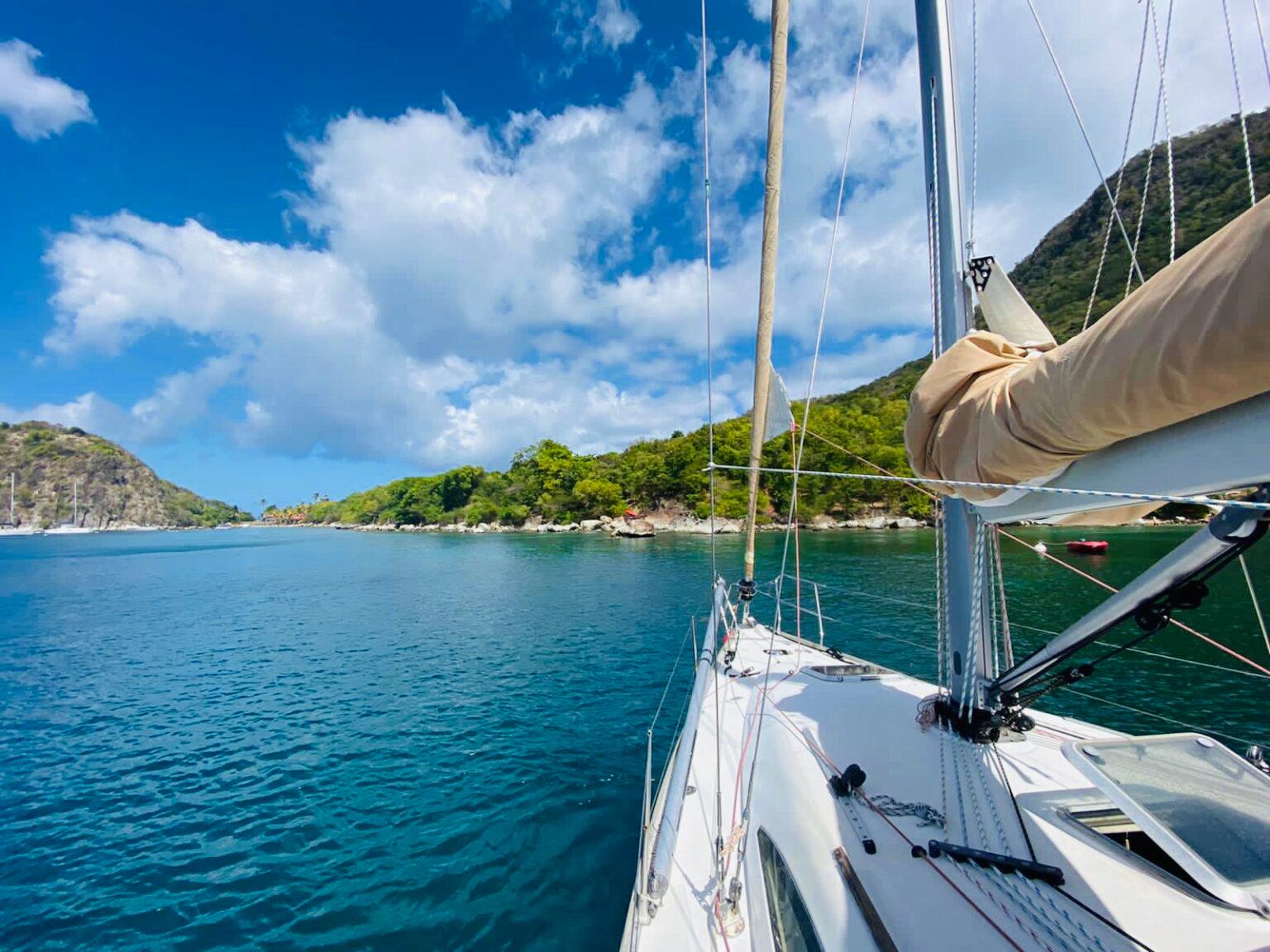 Un barco navegando por las aguas azules de Martinica y a lo largo de la costa con Rêve de Nav’ Guadeloupe.