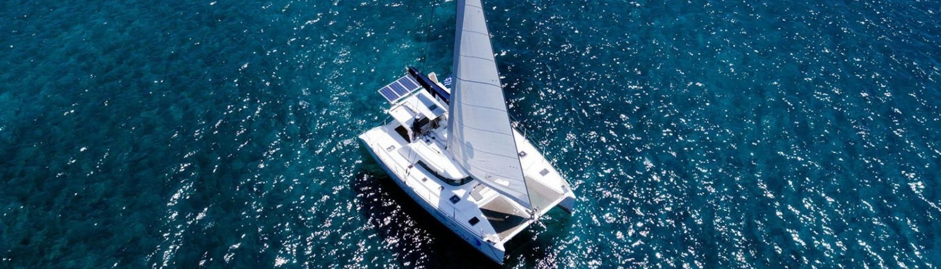 A catamaran on the beautiful sparkling water of the Cyclades from Volcano Yachting Santorini.