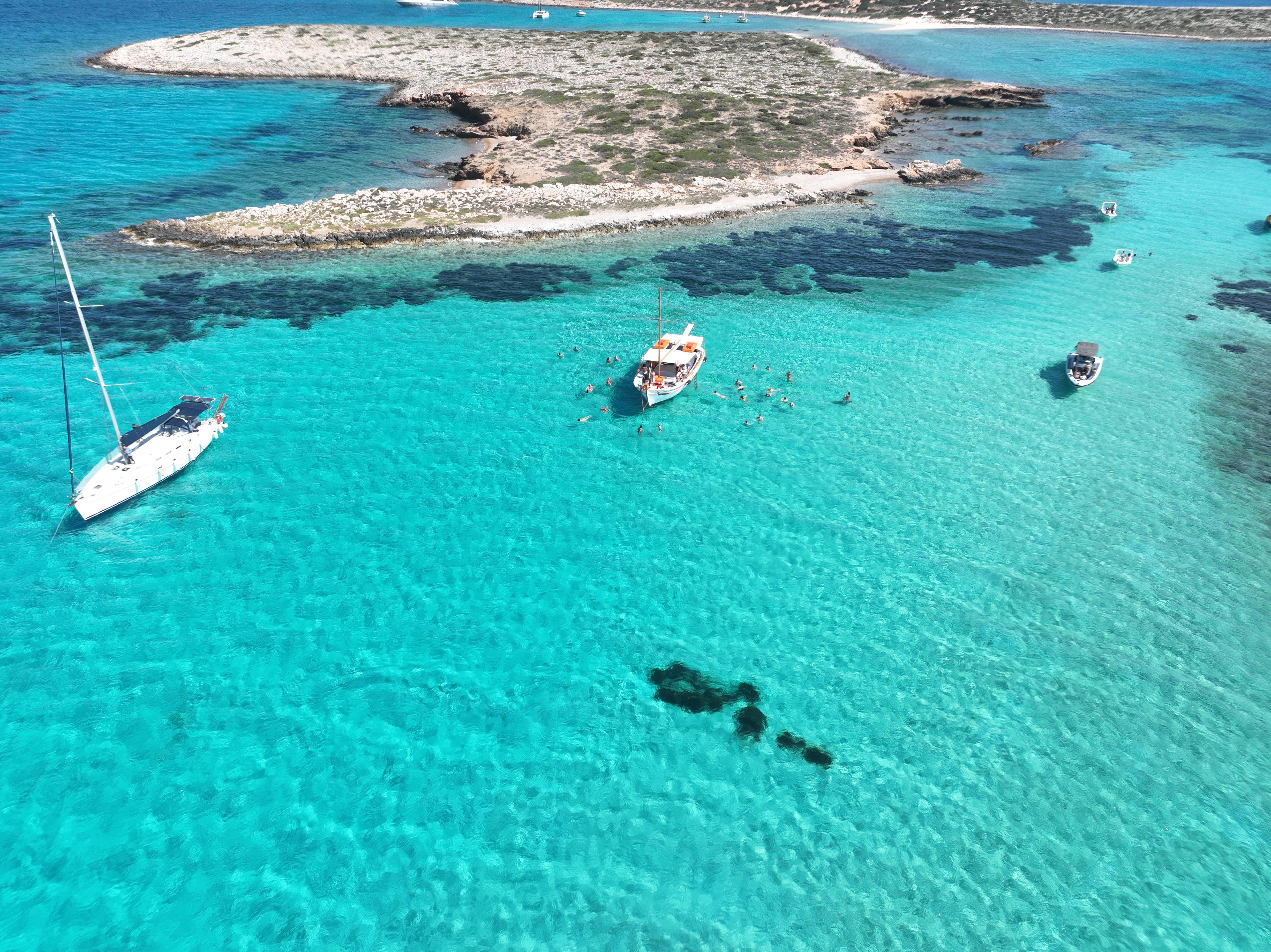 Quelques voiliers de Voreas Paros Cruises dans les eaux turquoises près de Paros lors d'une excursion en voilier.