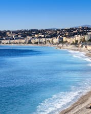 An image of the clear blue water of the French Riviera and the famous beach promenade that is visible to those who partake in some water sports in Nice.