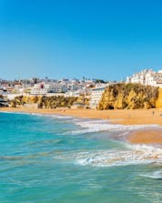 A view from the beach with the city in the background and the ocean where you can do water sports activities in Albufeira.