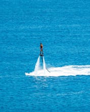 A photo of a brave young man mid-air above the ocean in Greece where you can do different water sports activities.
