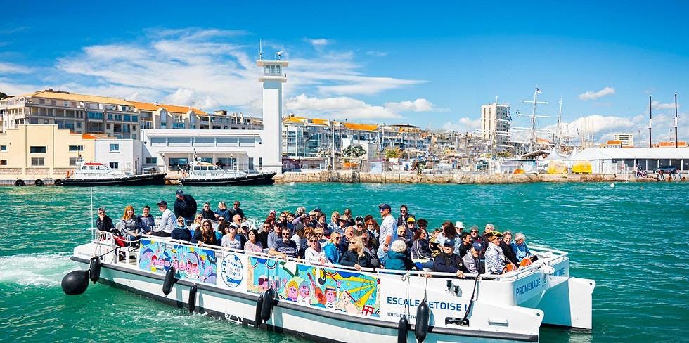 Escale Sétoise Eine Gruppe von Menschen besichtigt die Stadt auf einem Boot an einem sonnigen Tag mit Escale Sétoise.