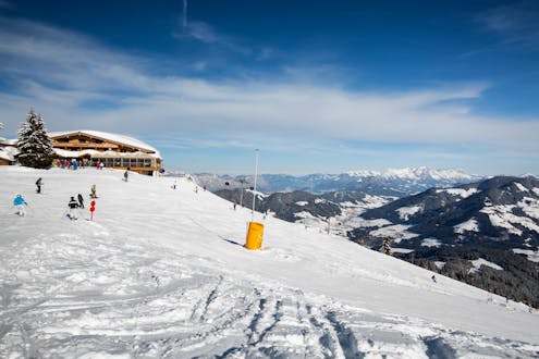 Adultos y niños esquiando en la estación de esquí de Wildschonau.