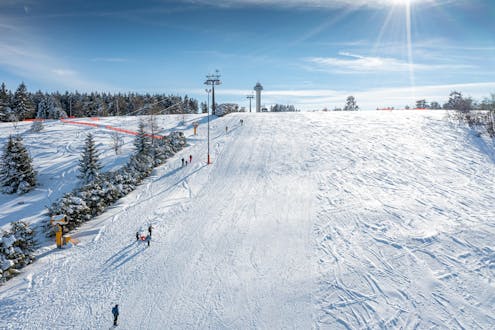 Adultos y niños esquiando en la estación de esquí de Willingen.