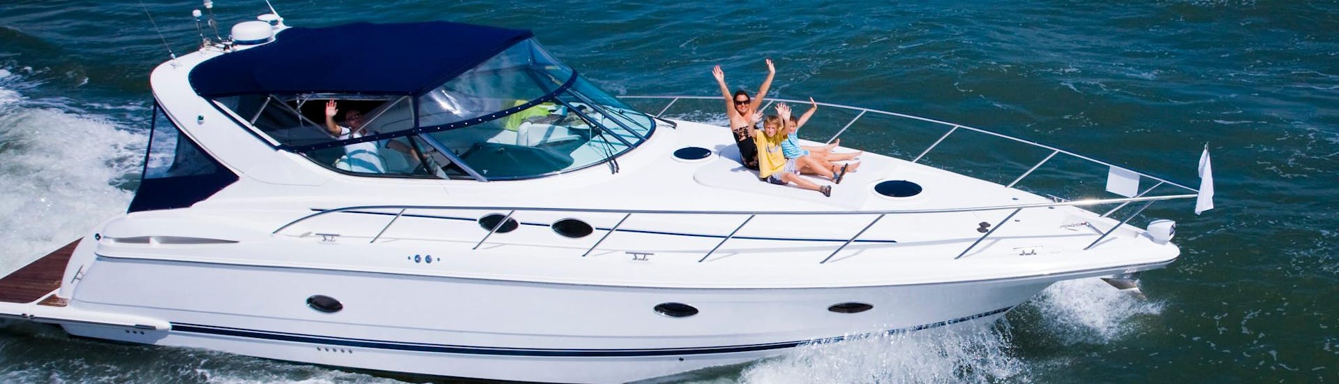 Une mère et deux enfants s'amusant lors d'une balade en yacht