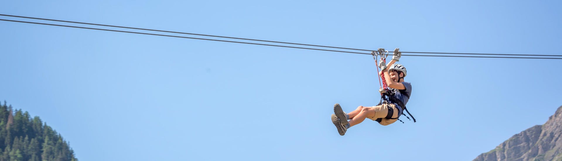 Un giovane uomo in volo sospeso da una zipline nell'hotspot di zipline presso Table Mountain National Park.