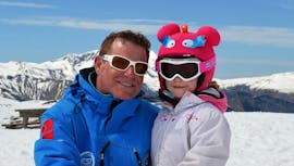 Ein Skilehrer der European Ski School und ein kleines Kind haben eine tolle Zeit auf den Pisten von Les Deux Alpes beim privaten Skikurs für Kinder.