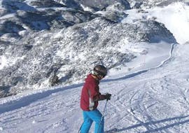 During the Private Ski Lessons for Adults - All Levels, an adult skier is taking the first steps on skis under the guidance of an experienced ski instructor from OUTdoor Slovenia Blend.