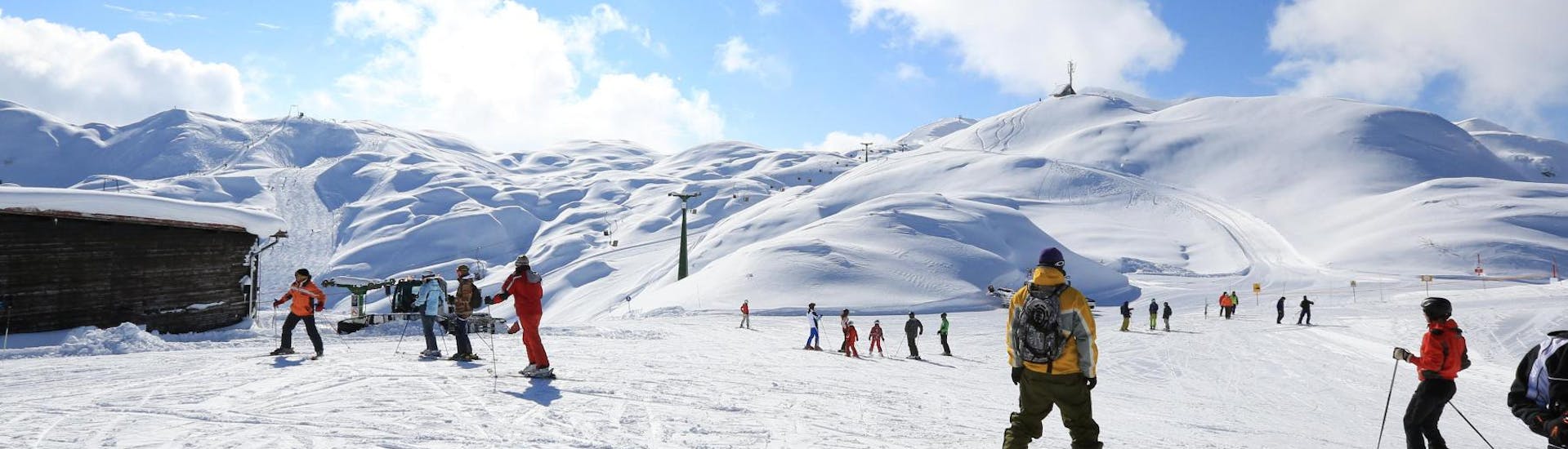 A group of adults is skiing under the guide of the instructor in their Private Ski Lessons for Adults - All Levels in OUTdoor Slovenia Blend slopes.