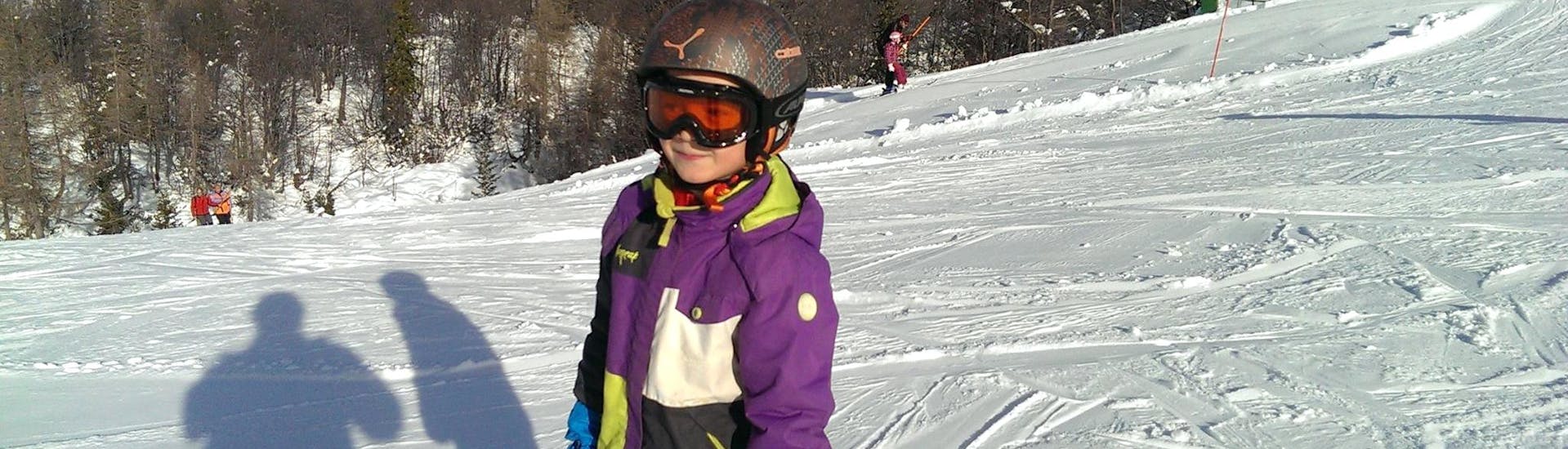 Ein Kind erfreut sich am maßgeschneiderten Privat-Skikurs für Kinder und an der vollen Aufmerksamkeit seines Skilehrers von der Slovenia Ski School - Für alle Levels.