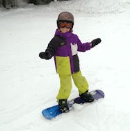Ein Kind hat viel Spaß beim Snowboard-Privatkurs für Kinder und Erwachsene, der von OUTdoor Slovenia Bled organisiert wird - Für alle Levels.