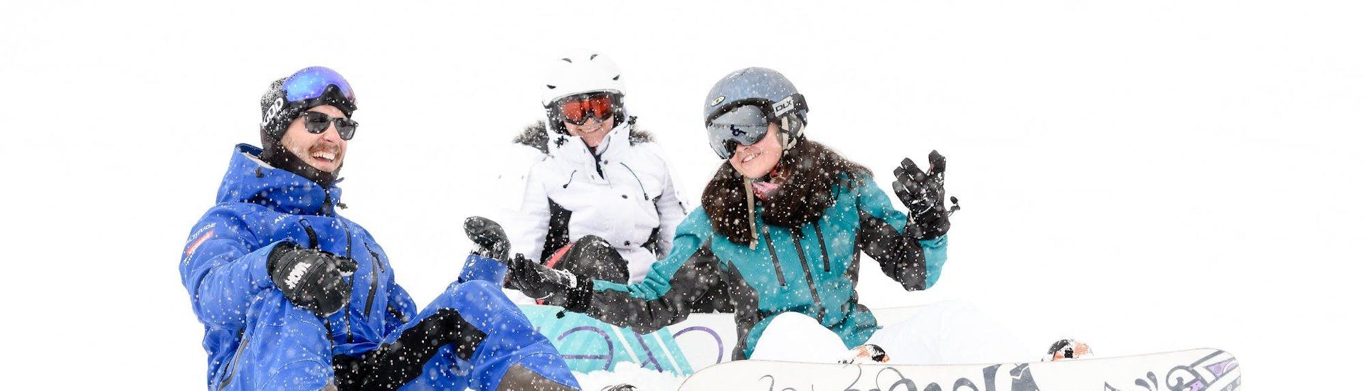 Three snowboarders sitting in the snow during their kids and adult snowboarding lessons for all levels with skischule Altitude in Grindelwald and Wengen.