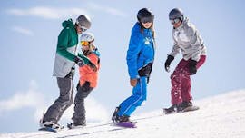 Four snowboarders are riding down a shallow slope during their kids and adult snowboarding lessons for all levels with skischule Altitude in Grindelwald and Wengen.
