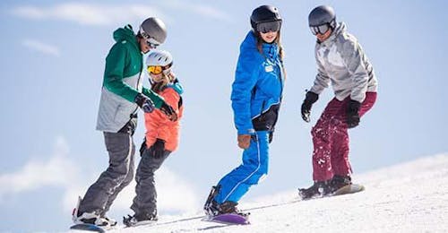 kids-and-adult-snowboarding-lessons-for-alle-levels-skischule-altitude-grindelwald-wengen Vier Snowboarderinnen und Snowboarder fahren einen flachen Hang hinunter, während sie mit der Skischule Altitude in Grindelwald und Wengen Snowboardkurse für Kinder und Erwachsene aller Stufen besuchen.