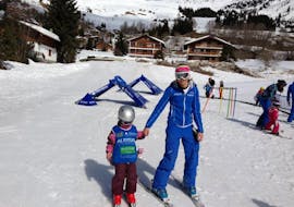 An instructor is holding and helping a child during its private ski lessons for kids in Grindelwald and Wengen with skischool Altitude.