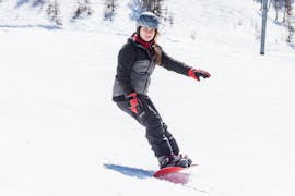 Eine Snowboarderin fährt einen Hang hinunter während ihres privaten Snowboardunterrichts für alle Stufen in Grindelwald und Wengen mit der Skischule Altitude.