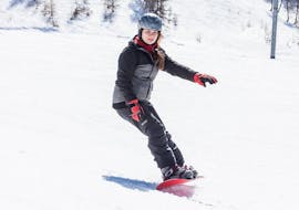A snowboarding is riding down a slope during her private snowboarding lessons for all levels in Grindelwald and Wengen with skischool Altitude.