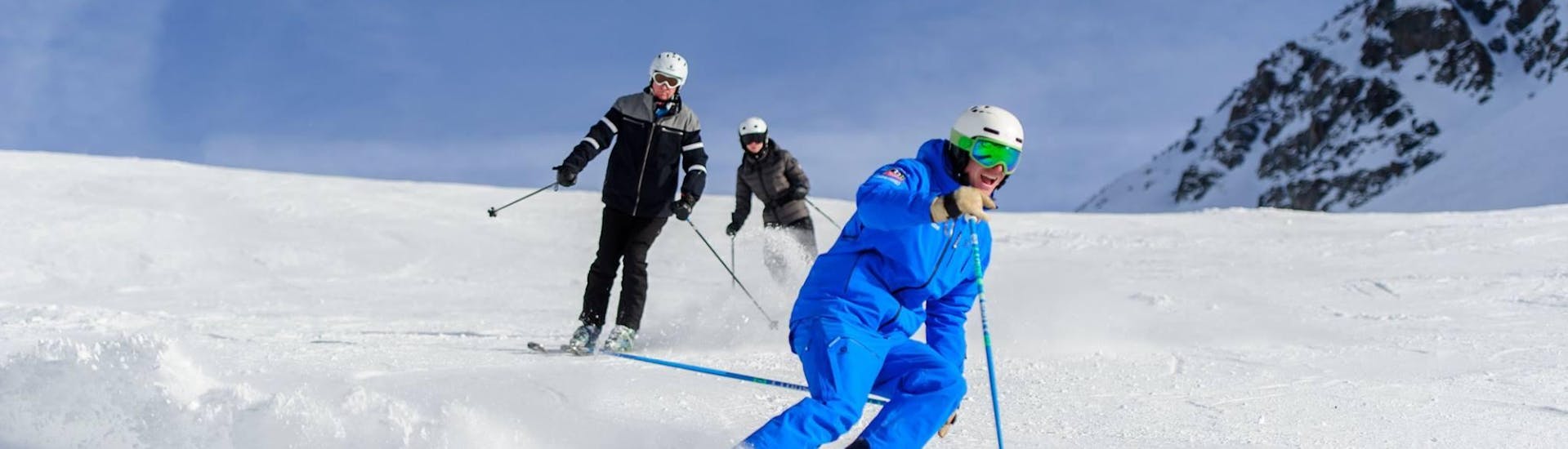 Tres esquiadores montaña abajo durante sus clases particulares de esquí fuera de pista para todos los niveles, con la escuela de esquí Altitude en Grindelwald y Wengen.