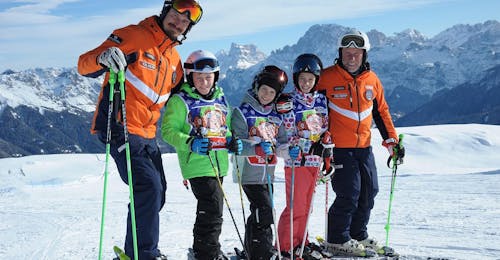 Lezioni di sci "Week4Kids Falcade" per Tutti i Livelli con Scuola di Sci Equipe Falcade Bambini e maestro di sci felici a Falcade durante una delle lezioni di sci per bambini "Week4Kids Falcade" per tutti i livelli.
