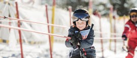 A boy is successfully taking the ski lift during kids ski lessons for beginners with ski school ruhpolding at the Westernberg ski area.