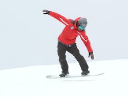 Un ragazzo durante le Lezioni di snowboard per bambini e adulti  con Ski School Top Ski Piculin San Vigilio.