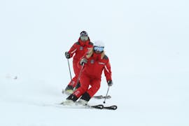 Uno sciatore e il suo istruttore durante le Lezioni private di sci per adulti per tutti i livelli con Ski School Top Ski Piculin San Vigilio.