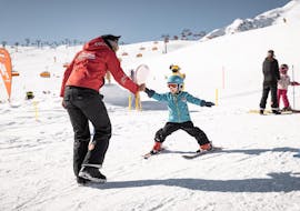 A young child is mastering their first steps on skis during the Kids Ski Lessons (3-4 years) - First Timer with an experienced instructor from Ski & Snowboardschool Vacancia.
