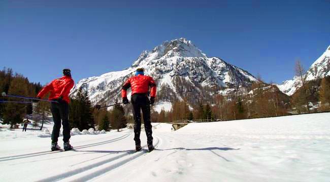 I fondisti si dirigono verso la montagna in una giornata di sole con la scuola di sci ESF Vallorcine durante le lezioni private di sci di fondo e biathlon - tutti i livelli.
