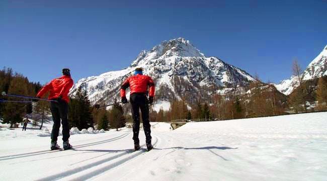 Private Cross Country Skiing & Biathlon Lessons for All Levels from Ski School ESF Vallorcine Cross-country skiers head towards the mountain on a sunny day with the ESF Vallorcine ski school during their Private Cross Country Skiing & Biathlon Lessons - All Levels.