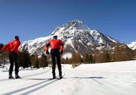 Langlaufers gaan op een zonnige dag de berg op met de ESF Vallorcine skischool tijdens hun privélessen langlaufen & biatlon - alle niveaus.