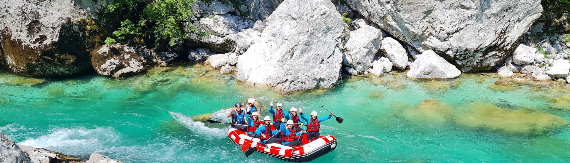 A boat with participants on the beautiful water during the Whitewater Rafting on the Soča River in Bovec.
