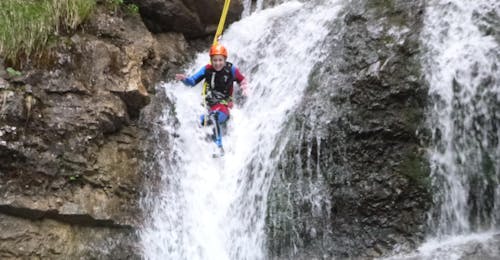Canyoning für Einsteiger bei Lenggries mit Outdoor Dahoam Lenggries Eine Person welche einen Wasserfall hinunterrutsch beim Canyoning für Einsteiger bei Lenggries mit Outdoor Dahoam Lengries.