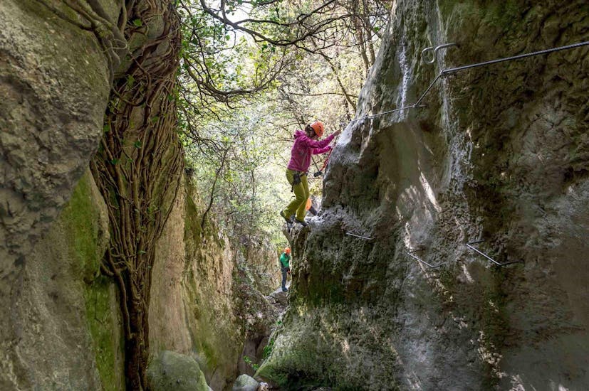 Ein Teilnehmer konzentriert sich auf den Aufstieg während des Klettersteigs Rio Sallagoni am Gardasee für Einsteiger.