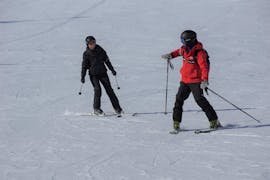 Un moniteur de ski enseigne le ski à un participant aux cours particuliers de ski pour adultes - tous niveaux organisés par l'école de ski et de snowboard Vacancia dans la station de ski de Sölden.