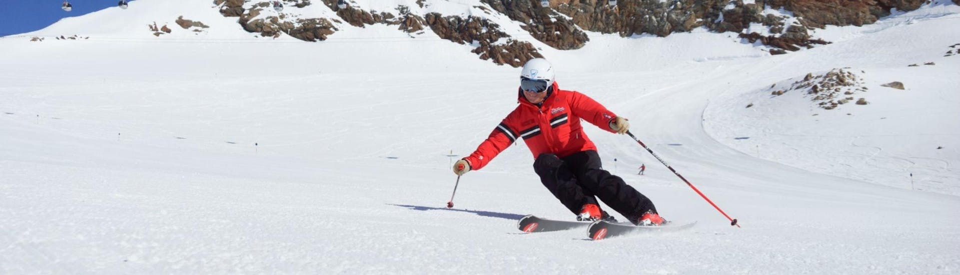 Un moniteur de ski de l'école de ski Ski- und Snowboardschule Vacancia montre la bonne technique de ski pendant un des cours particuliers de ski pour adultes - tous niveaux.