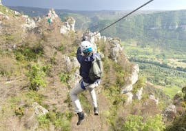 A man is doing zip line during his activity Via Ferrata "Nature" in the Gorges du Tarn  with B&ABA Sport Nature.