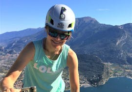Una partecipante della Via Ferrata a Cima Capi organizzata da LOLgarda sta sorridendo alla fotocamera durante una scalata sul lago di Garda.