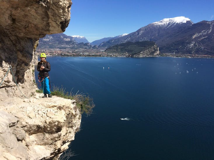 A participant with on the background a great view of the Garda Lake during the activity Via Ferrata along the Sentiero dei Contrabbandieri organized by LOLgarda.