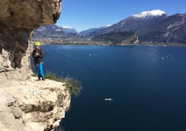 Une participante avec en arrière-plan une vue magnifique sur le lac de Garda pendant l'activité Via Ferrata le long du Sentiero dei Contrabbandieri organisée par LOLgarda.