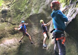 Three participants of the Via Ferrata along Rio Sallagoni are smiling at the camera during the activity organized by LOLgarda.