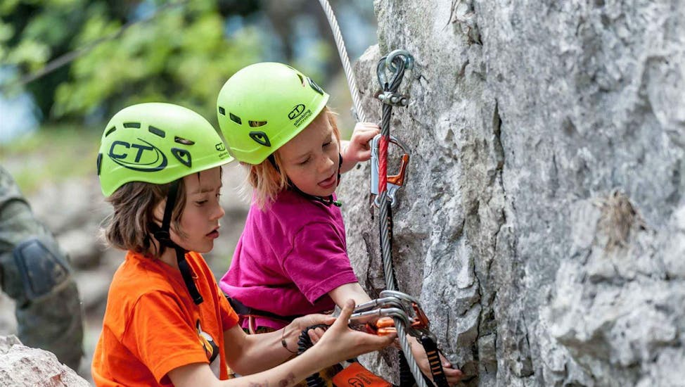 Zwei Kinder beginnen ihre erste Kletterpartie auf dem Klettersteig Colodri in Arco für Familien mit Mmove - Into Nature Gardasee.