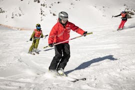 Un maestro di sci della scuola di sci Ski- und Snowboardschule Vacancia insegna a un bambino a sciare durante le lezioni private di sci per bambini - tutti i livelli.