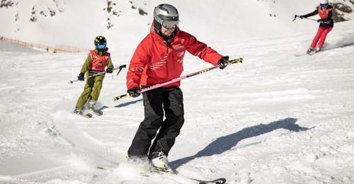 Lezioni private di sci per bambini e ragazzi di tutti i livelli Un maestro di sci della scuola di sci Ski- und Snowboardschule Vacancia insegna a un bambino a sciare durante le lezioni private di sci per bambini - tutti i livelli.